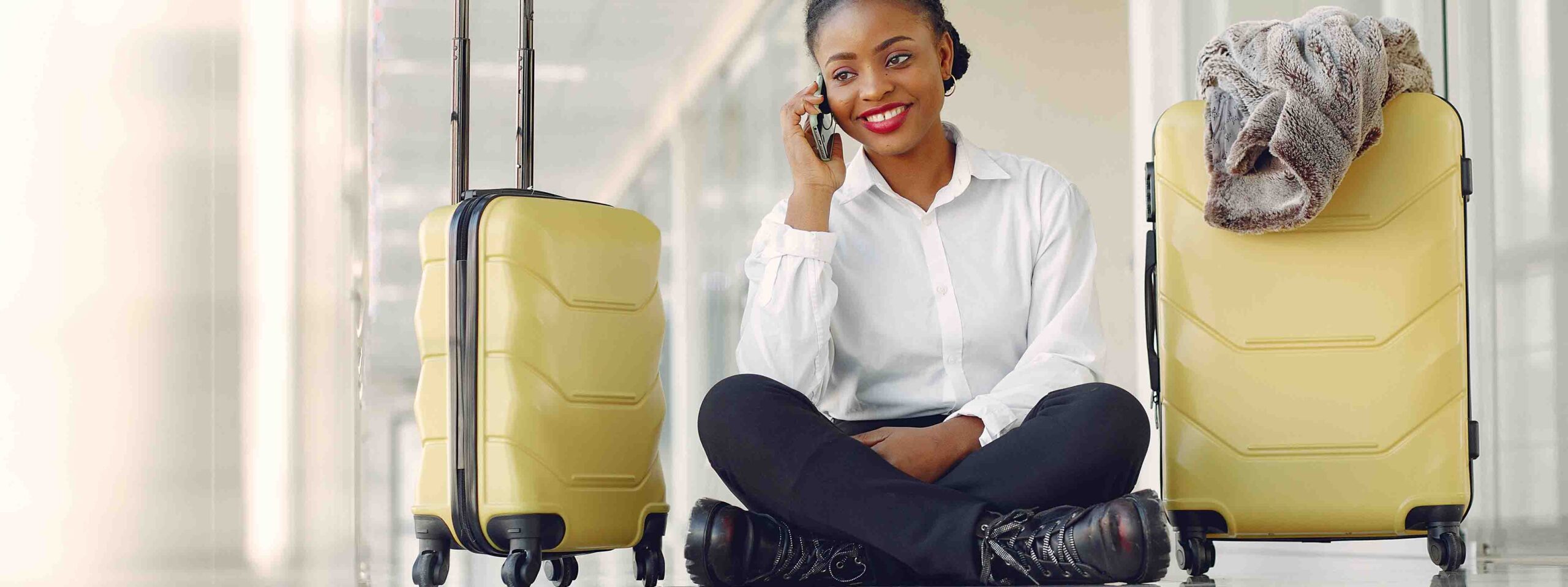 Black woman at the airport. Girl with suitcase. Lady in a white shirt.